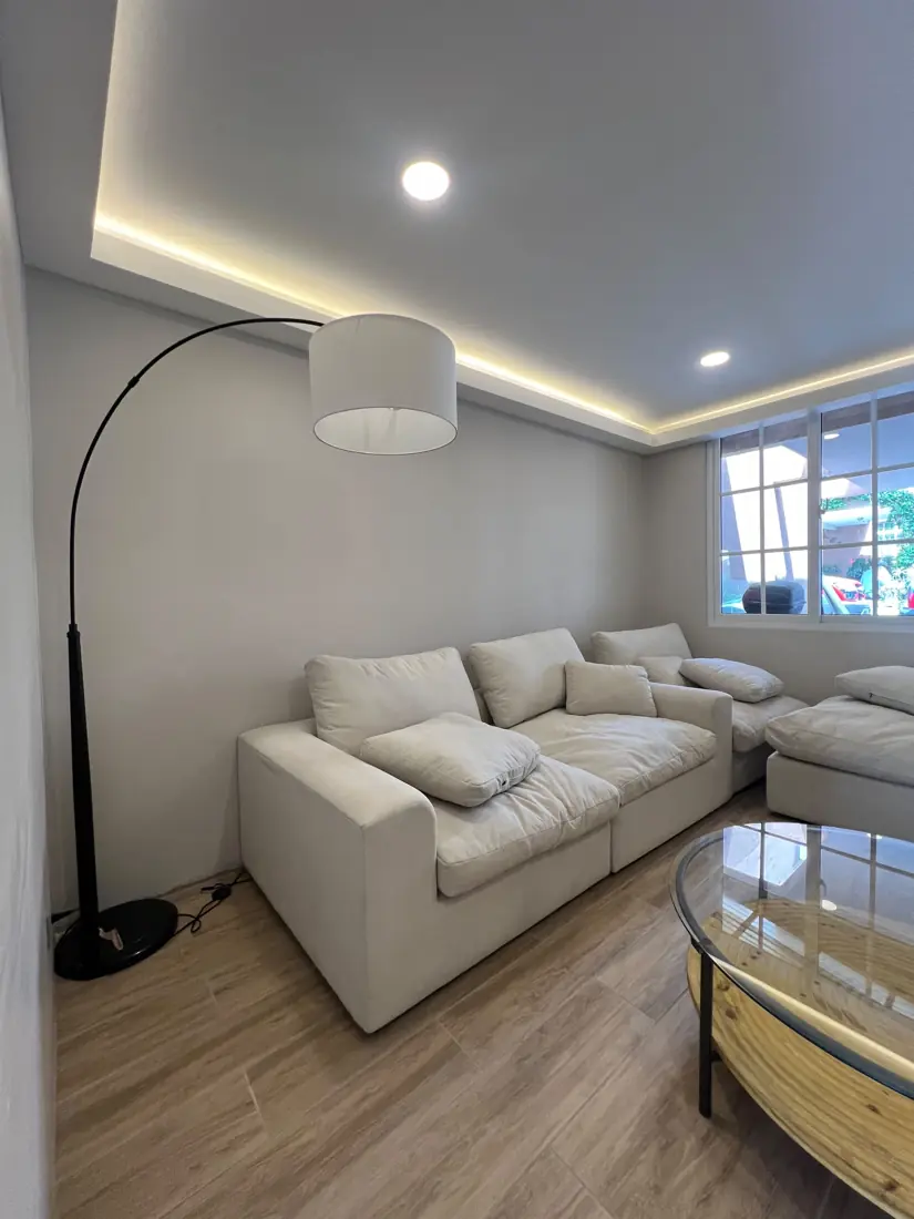 Sala residencial remodelada con cielo falso perimetral e iluminación LED cálida