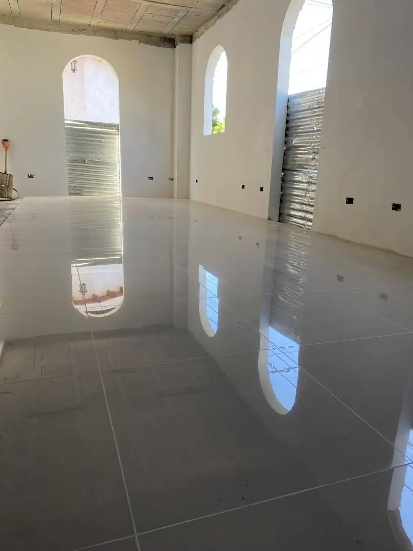 Salón con piso de porcelanato y ventanas en arco
